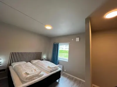 a bedroom with a bed with white sheets and a window at Åndalsnes house in Åndalsnes