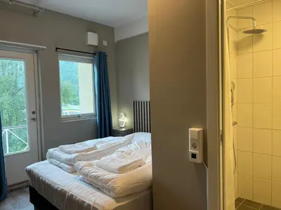a bed in a room with a window and a room with at Åndalsnes house in Åndalsnes