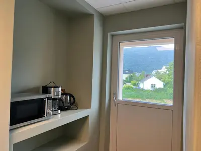 a door to a room with a microwave and a window at Åndalsnes house in Åndalsnes