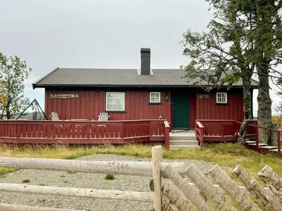 a red house with a fence in front of it at Family Cabin With Sun And Views At Ljøsheim in Mesnali