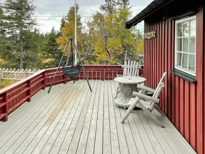 a porch with a swing and a chair on a deck at Family Cabin With Sun And Views At Ljøsheim in Mesnali
