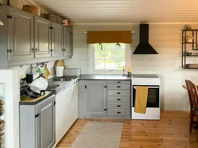 a kitchen with white cabinets and a window at Family Cabin With Sun And Views At Ljøsheim in Mesnali