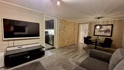 a living room with a couch and a flat screen tv at Rancho Apartment in Langevåg in Sula