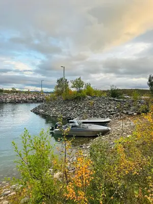 two boats are docked on the shore of a river at Møsstrond Turisthytte in Hovden