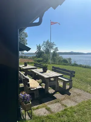 a picnic table and chairs with a view of the water at Møsstrond Turisthytte in Hovden