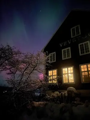 a house at night with the lights on at The blue room at Vevstogo - cosy with a mesmerizing view, sauna and eco living in an old school house in Løken