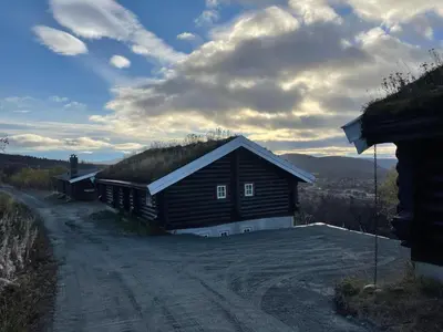a house with a grass roof on a dirt road at Large Cabin With Stunning Views! in Beitostøl