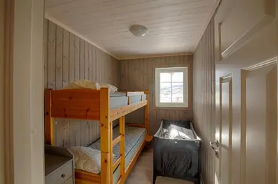 a small room with two bunk beds and a window at Modern Cabin At The Foot Of Bitihorn in Beitostøl