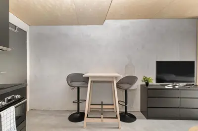 a living room with two stools and a table at Comfy studio apartment 200m from bryggen in Bergen