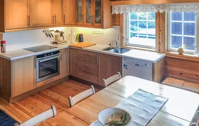 a kitchen with wooden cabinets and a table and a sink at Beautiful Home In Rjukan With Wifi in Rjukan
