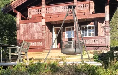 a swing in front of a wooden house at Beautiful Home In Rjukan With Wifi in Rjukan