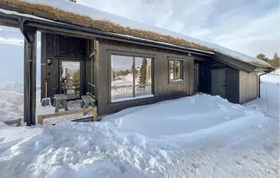 a cabin with a pile of snow in front of it at Gorgeous Home In Kvam With Sauna in Kvam