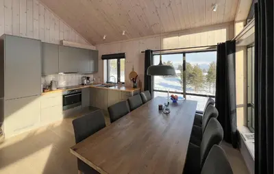 a kitchen and dining room with a wooden table and chairs at Gorgeous Home In Kvam With Sauna in Kvam