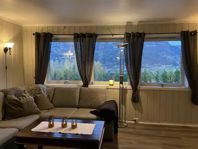 a living room with a couch and a large window at Leilighet i Sør-Fron kommune in Sør-Fron