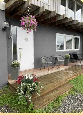 a wooden deck with chairs and a table with flowers at Leilighet i Sør-Fron kommune in Sør-Fron