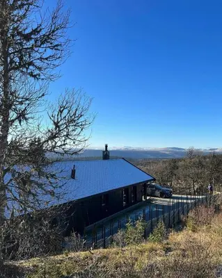 a house with a solar roof on top of it at Family Cabin With Jotunheim Mountain Views in Venabygd