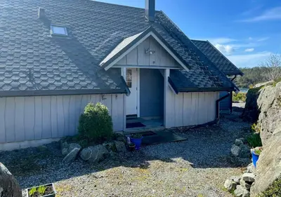 a house with a pitched roof and a yard at Seaside Cabin With Archipelago Views In Radøy in Bøvågen
