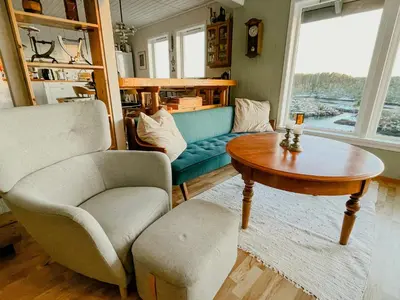 a living room with a couch and a table at Seaside Cabin With Archipelago Views In Radøy in Bøvågen