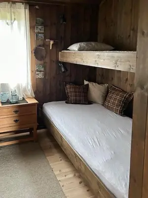 a bedroom with a bunk bed and a night stand at Mountain Cabin With Views At Skeikampen in Svingvoll