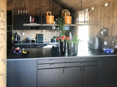 a kitchen with a counter with vases of flowers on it at Mountain Cabin With Views At Skeikampen in Svingvoll