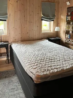 a large bed in a room with wooden walls at Mountain Cabin With Views At Skeikampen in Svingvoll