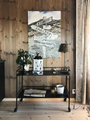 a black table with a picture on a wooden wall at Mountain Cabin With Views At Skeikampen in Svingvoll