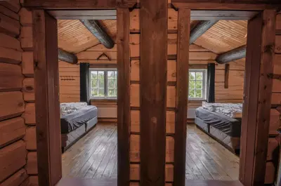 a room with two beds in a log cabin at Charming Timber Lodge For Gathering And Celebrations in Beitostøl