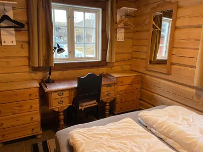 a bedroom with a desk and a bed and a desk and window at Charming Timber Lodge For Gathering And Celebrations in Beitostøl