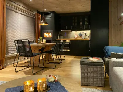 a living room with a table and chairs and a kitchen at Modern Apartment With Views Of Trysil Mountain in Trysil