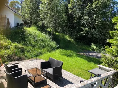 a deck with chairs and a coffee table on a yard at Child-friendly holiday home in Ålesund