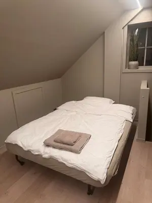 a white bed with a towel on top of it at Central apartment in idyllic Bakklandet in Trondheim