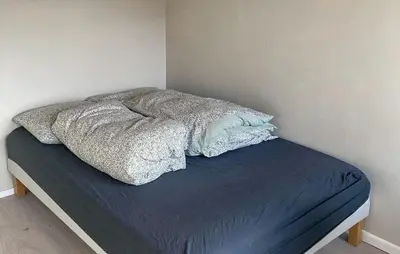 an unmade bed in a corner of a bedroom at Lovely Home In Flaktveit With Wifi in Blinde
