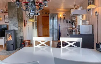 a kitchen with a white table and two white chairs at 2 Bedroom Amazing Home In Agdenes in Fremstad