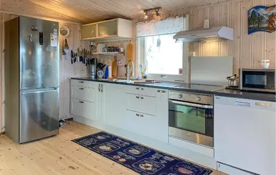 a kitchen with white cabinets and a stainless steel refrigerator at 2 Bedroom Amazing Home In Agdenes in Fremstad