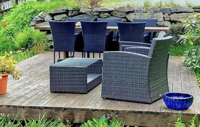 a bunch of wicker chairs and tables on a wooden deck at 3 Bedroom Lovely Home In Valen in Valen
