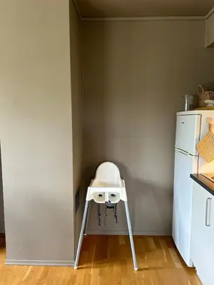 a high chair in a kitchen next to a refrigerator at Leilighet i 1 etg Røldal in Håra