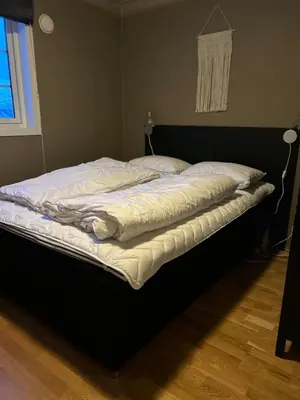 a bed with white sheets and pillows on it at Leilighet i 1 etg Røldal in Håra