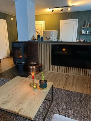 a living room with a table and a fireplace at Cabin in Valldalen, Røldal in Røldal