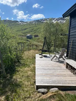 a wooden deck with a bench and a house at Cabin in Valldalen, Røldal in Røldal
