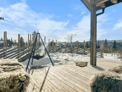 a hammock on a wooden deck in the snow at Modern Family Cabin at Norefjell - Views and Hiking in Eggedal