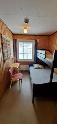 a room with two bunk beds and a table and a chair at Haugen Gård in Oppdal