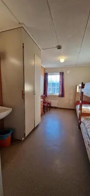 a room with a room with two beds and a desk at Haugen Gård in Oppdal