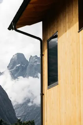 a view of the mountains through a window at The Crux Nordic Design Mountain Cabin in Åndalsnes