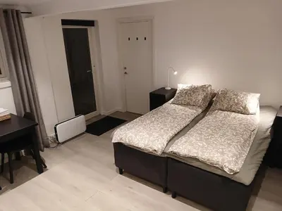 a bedroom with a large bed and a desk and a desk at studio apartment 24 sqm in Trondheim