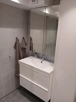 a bathroom with a white sink and a mirror at studio apartment 24 sqm in Trondheim