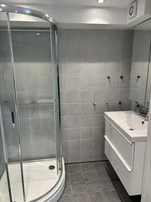 a bathroom with a shower and a toilet and a sink at studio apartment 24 sqm in Trondheim