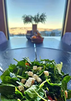 a table with a plate of salad on a table at The Holiday - Panorama Lodge in Lampeland