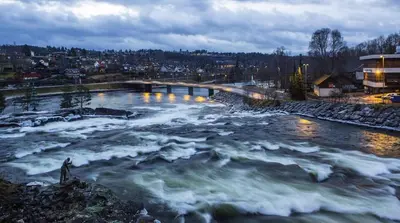 a river with a bridge over it with waves at The Holiday - Panorama Lodge in Lampeland