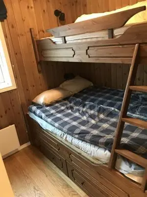 a bunk bed in a wooden room with a ladder at Trysilmountainlodge in Hovi