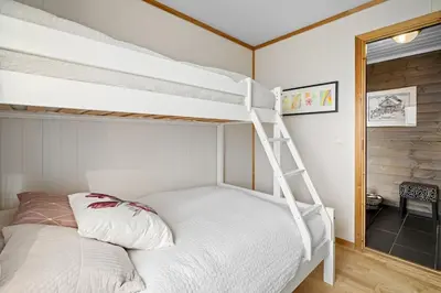 a bedroom with a bunk bed with a ladder at Lovely apartment with amazing view and sauna in Skulestadmo